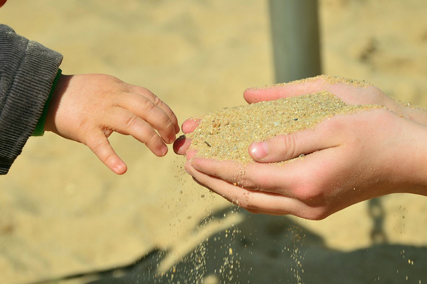 child touching sand